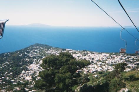 View from the Monte Solaro chairlift over white houses and the sea