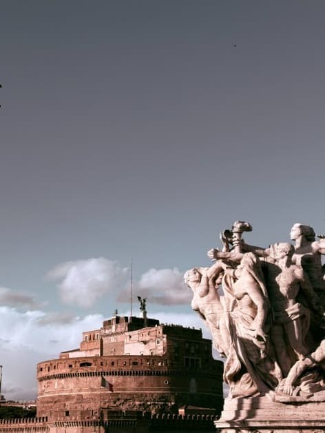 Castel Sant'Angelo beside a marble statue group on the bridge